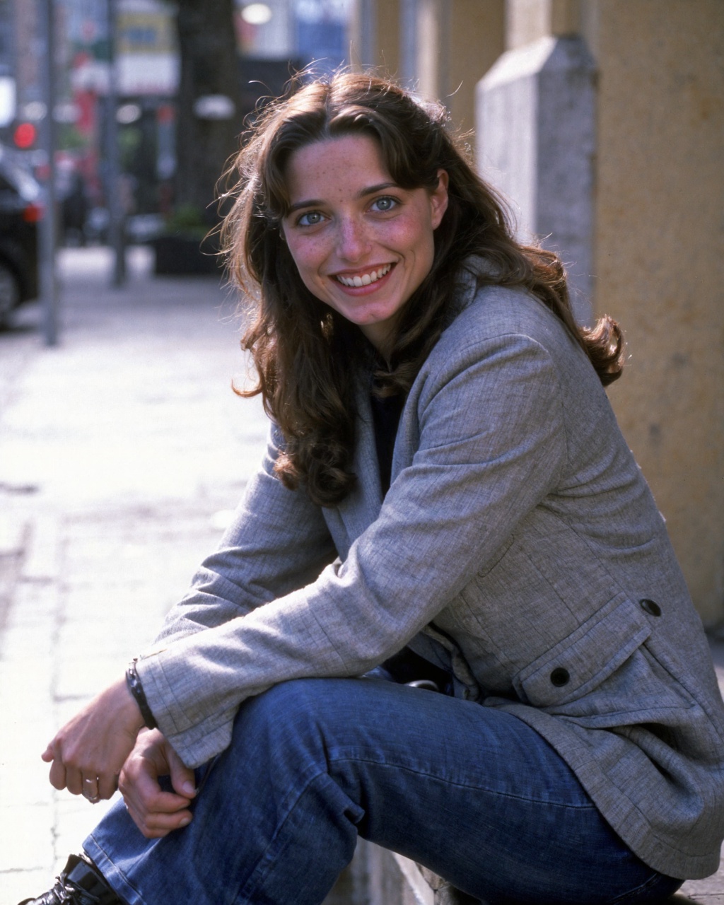 karen_allen sitting on a stone step,  likely in an urban setting. She has long,  wavy on Tensor.Art