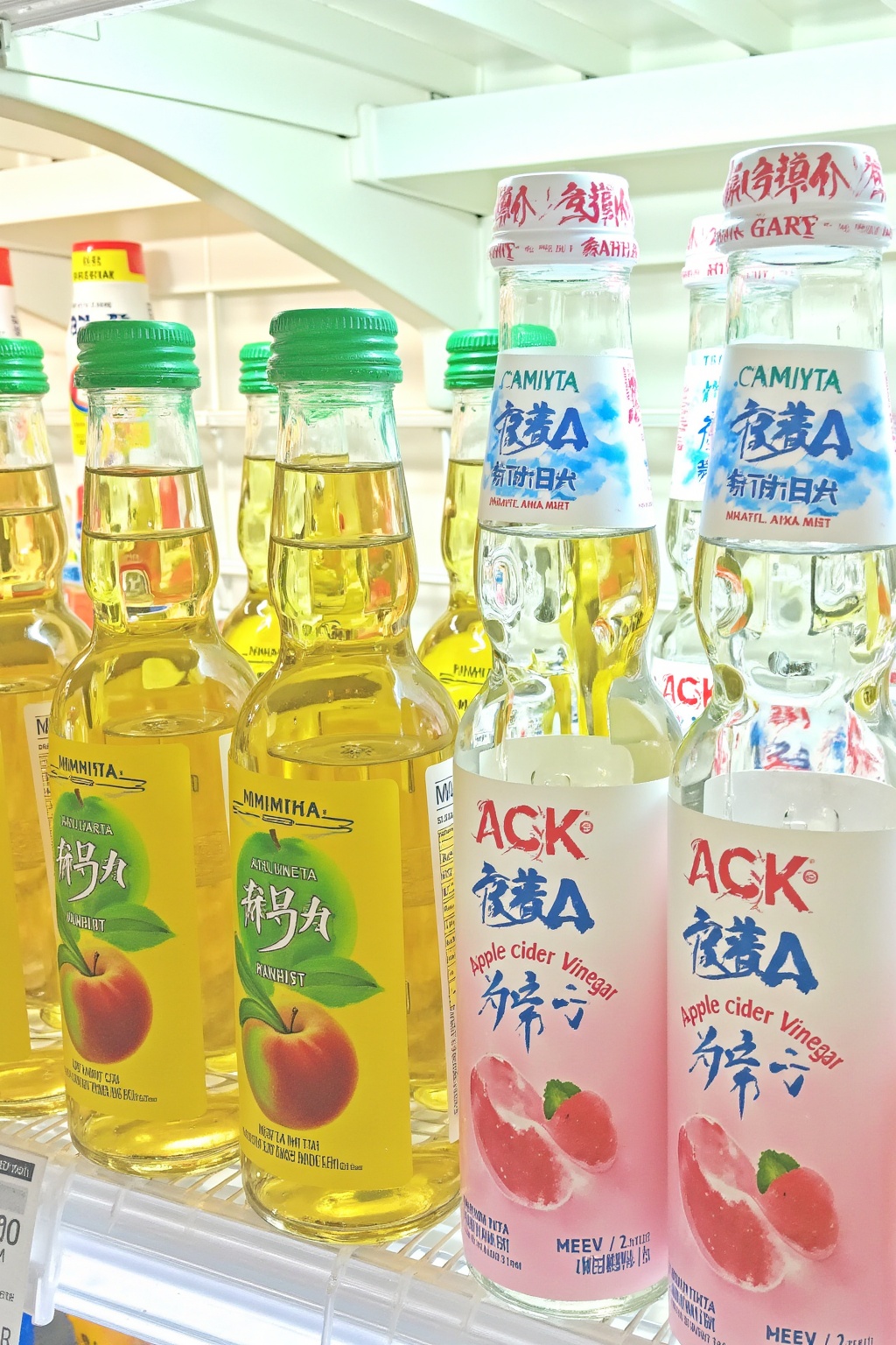 a refrigerator filled with bottles of different types of drinks,including apple cider vinegar. The bottles are arranged neatly on the shelf,giving the viewer a clear view of the contents.,