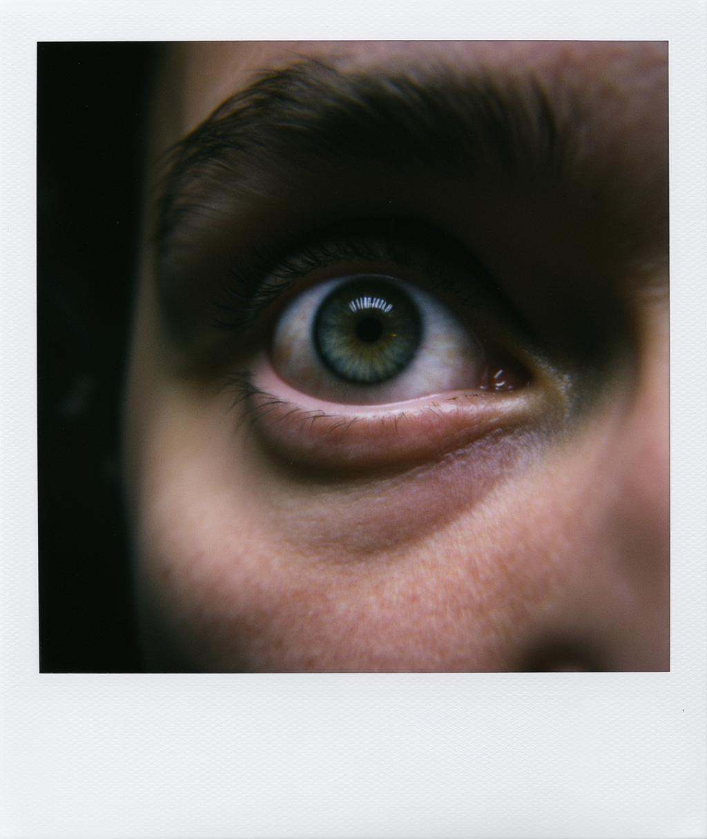 Polaroid frame of close up shot of very realistic portrait shot of an anxious looking eye,  highly detailed,  cinematic on...