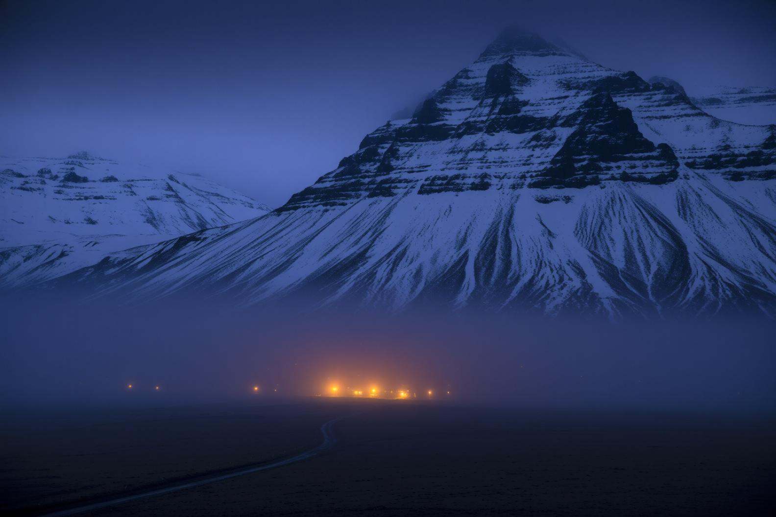 aurelmanea2q photography.A landscape at dusk or nighttime. The foreground consists of a flat,  dark terrain,  possibly a f...