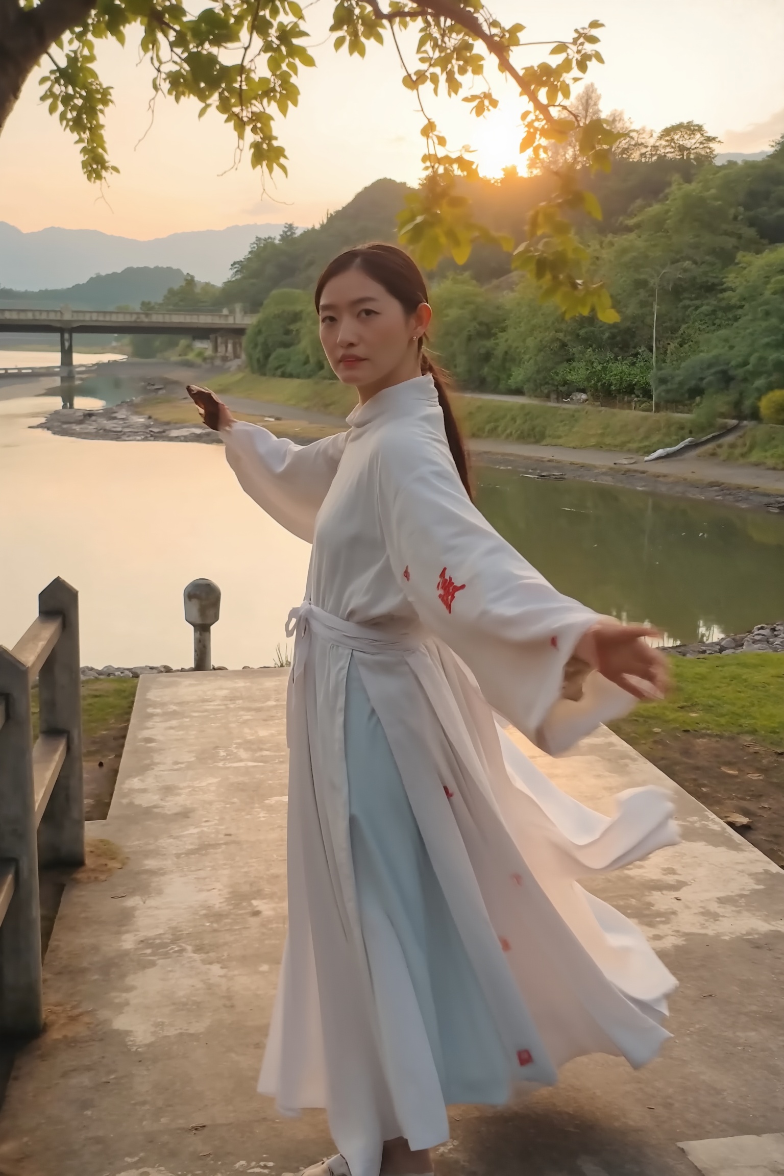 A beautiful woman in a traditional Chinese hanfu,  standing on a riverbank park in the early morning,  performing a gracef...