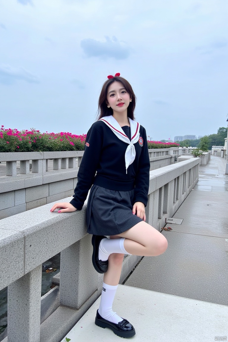 A girl dressed in a black and white school uniform, adorned with a red bow in her hair. She is perched on a concrete railing, her left hand resting on the railing. The woman's right leg is crossed, her right leg resting on a white platform. The backdrop, a row of pink flowers can be seen, adding a touch of color to the scene. The sky is a muted blue, with a few wispy clouds in the sky.
