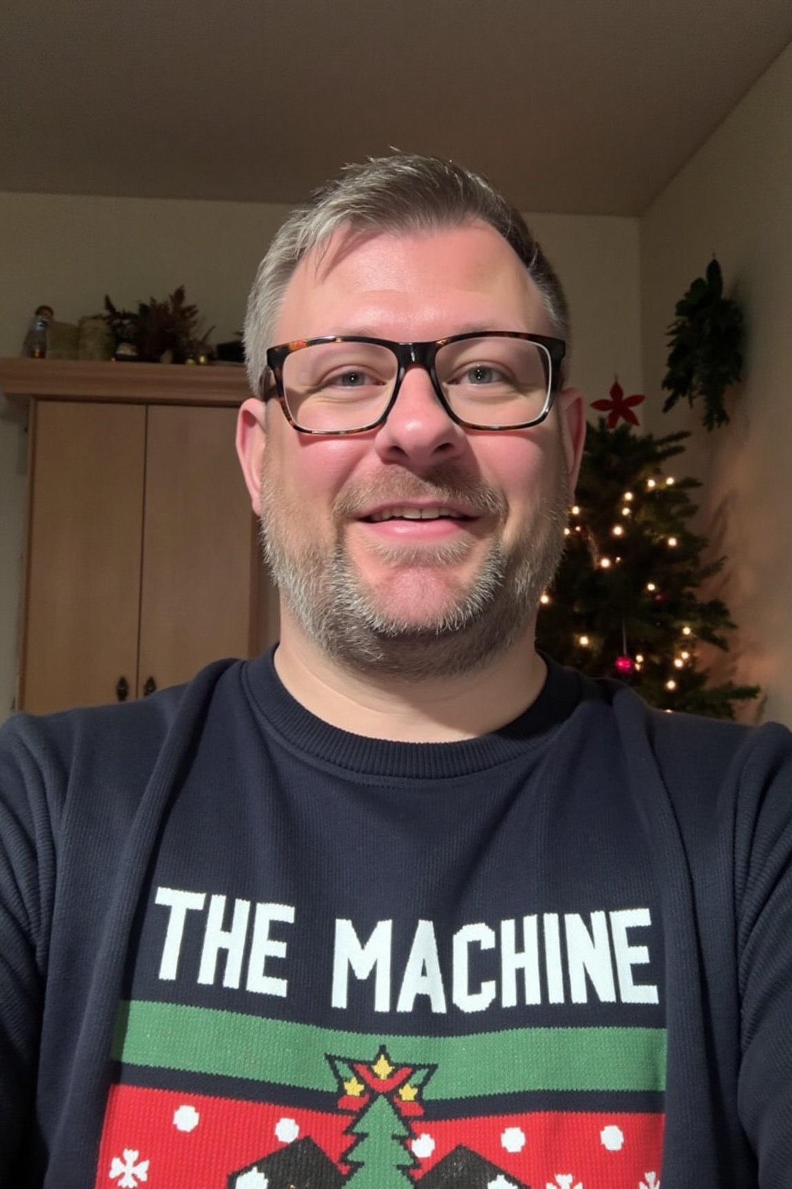The image is a high-resolution photograph of James Wade,  wearing a Christmas themed sweater with the words "THE MACHINE"...