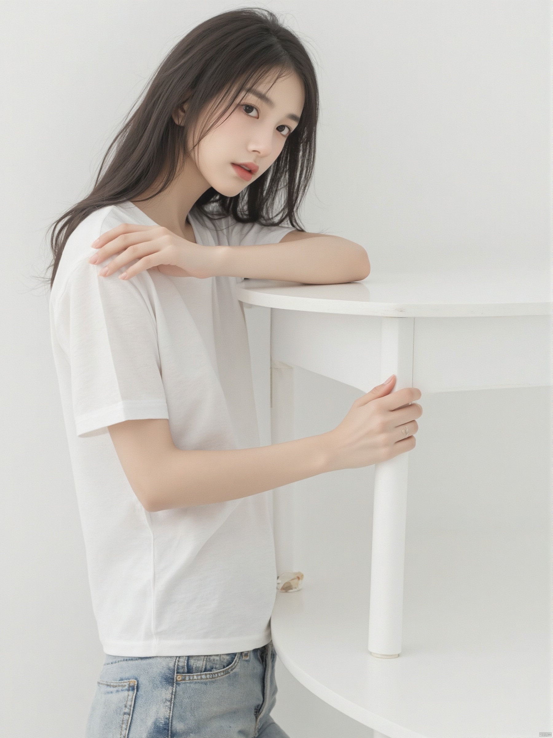 a young Asian woman with long dark brown hair, wearing a white short-sleeved t-shirt and jeans, is leaning on a white table. Her left hand is resting on the table, adding a touch of touch to the scene. The backdrop is a stark white wall, creating a stark contrast to the woman's white shirt.