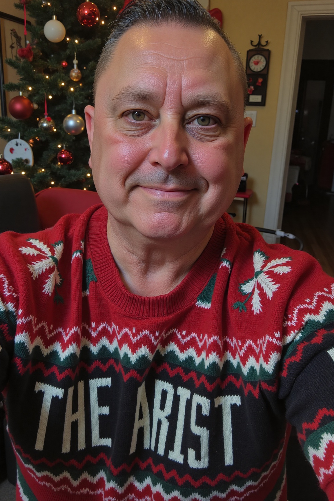 The image is a high-resolution photograph of Kevin Painter,  wearing a Christmas themed sweater with the words "THE ARTIST...