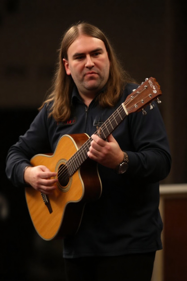 A high-resolution photograph of Ryan Searle,  playing an acoustic guitar on Tensor.Art