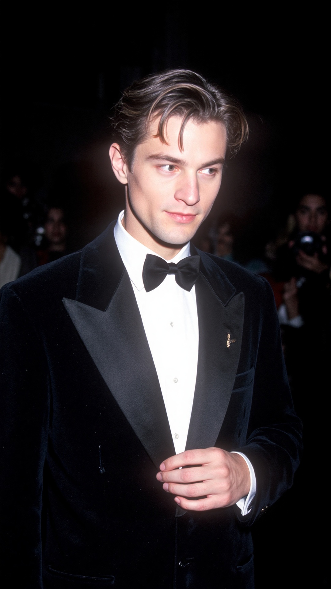 a 2000s paparazzi photo of a 18 years old handsome young man,  he is wearing a black velvet tuxedo by Gucci by Tom Ford. H...