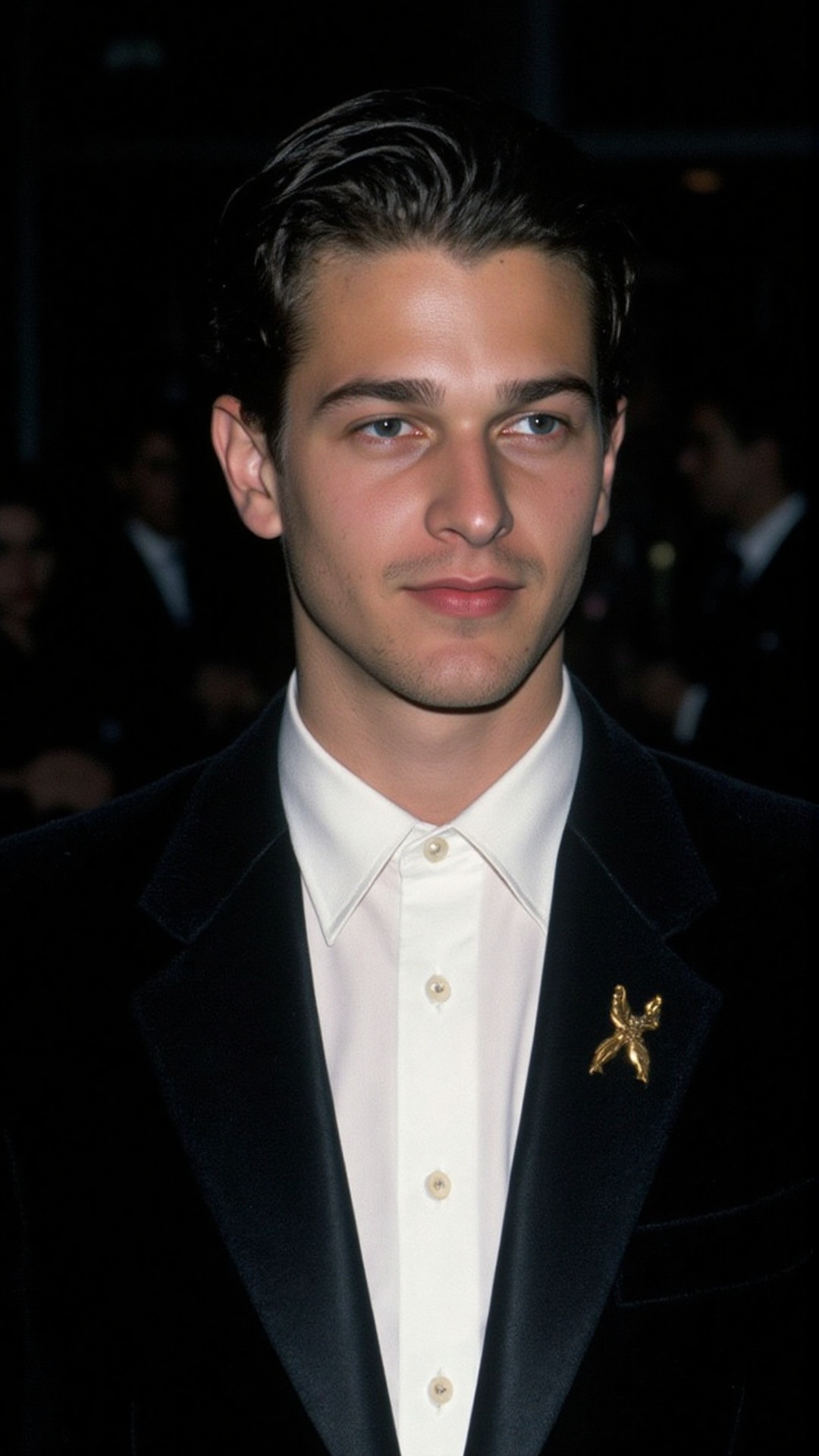 a 2000s paparazzi photo of a 18 years old handsome young man,  he is wearing a black velvet tuxedo by Gucci by Tom Ford. H...