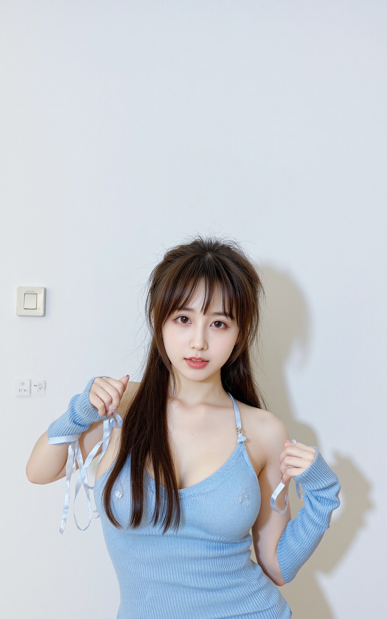 a young Asian woman is striking a pose in front of a white wall. She is dressed in a blue dress,  adorned with long sleeve...