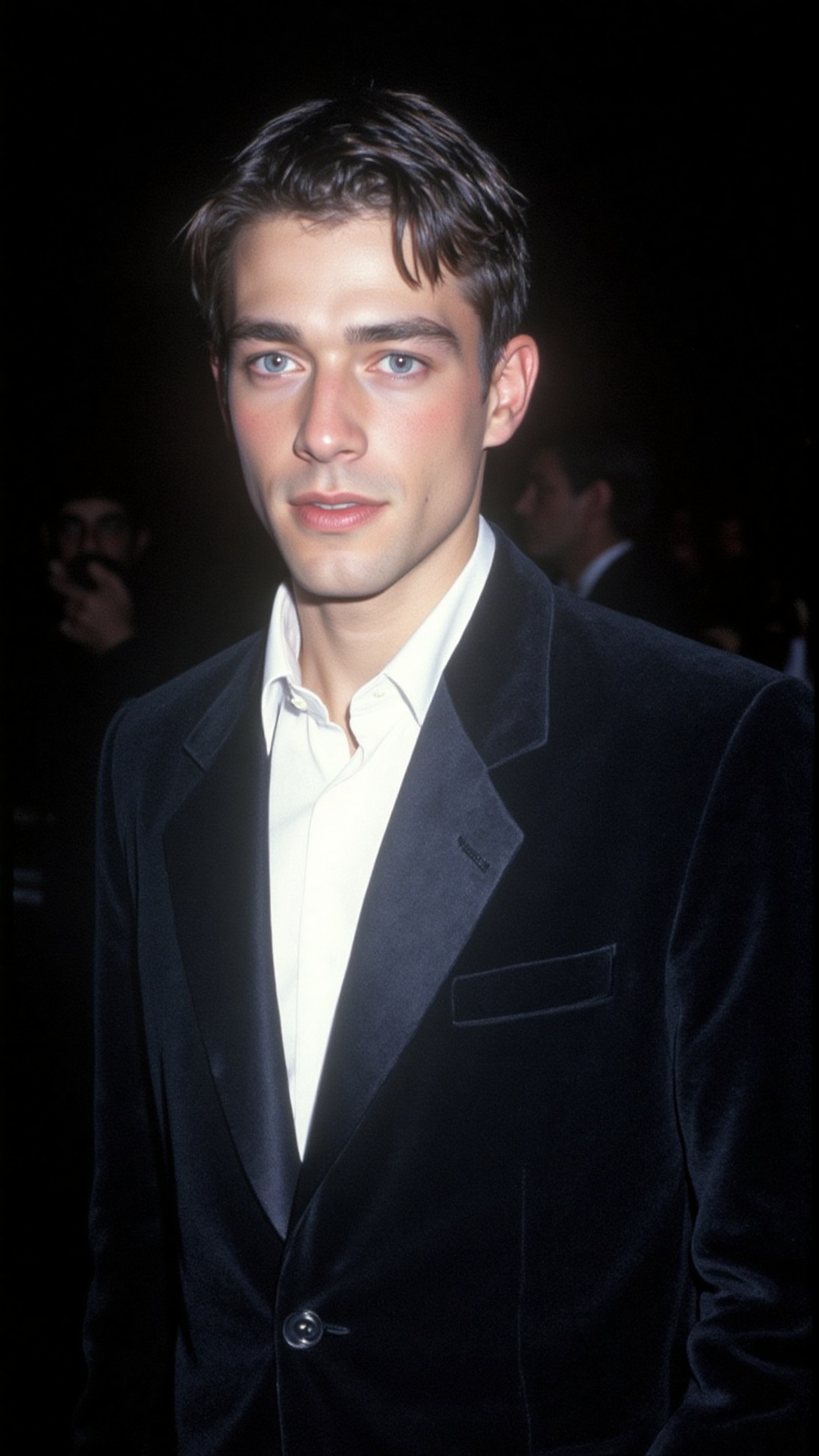 a 2000s paparazzi photo of a 18 years old handsome young man,  he is wearing a black velvet tuxedo by Gucci by Tom Ford. H...