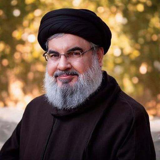 dressed in traditional religious attire. He is wearing a black turban,  Hassan Nasrallah. The image is a photograph of an...