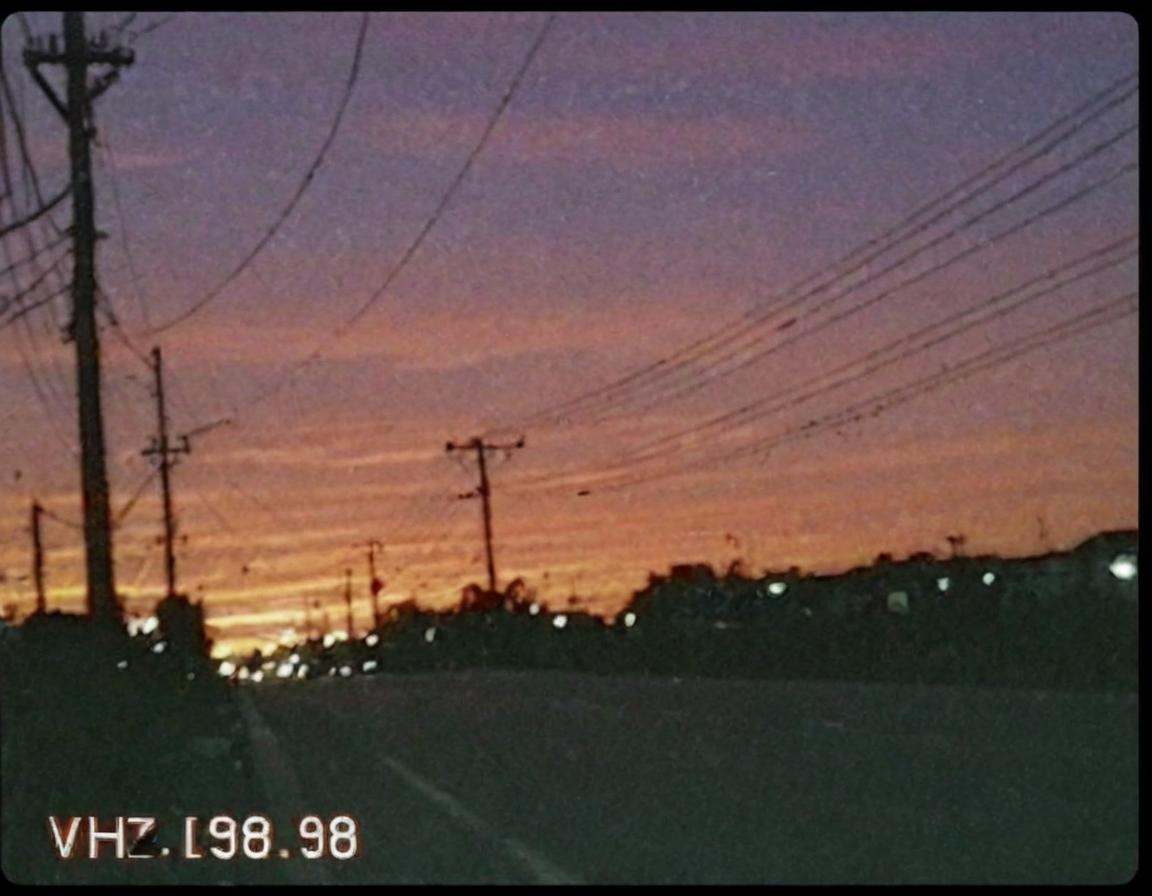 vhscore808,  Vibrant orange sunset sky with power lines and street lights,  low resolution on Tensor.Art