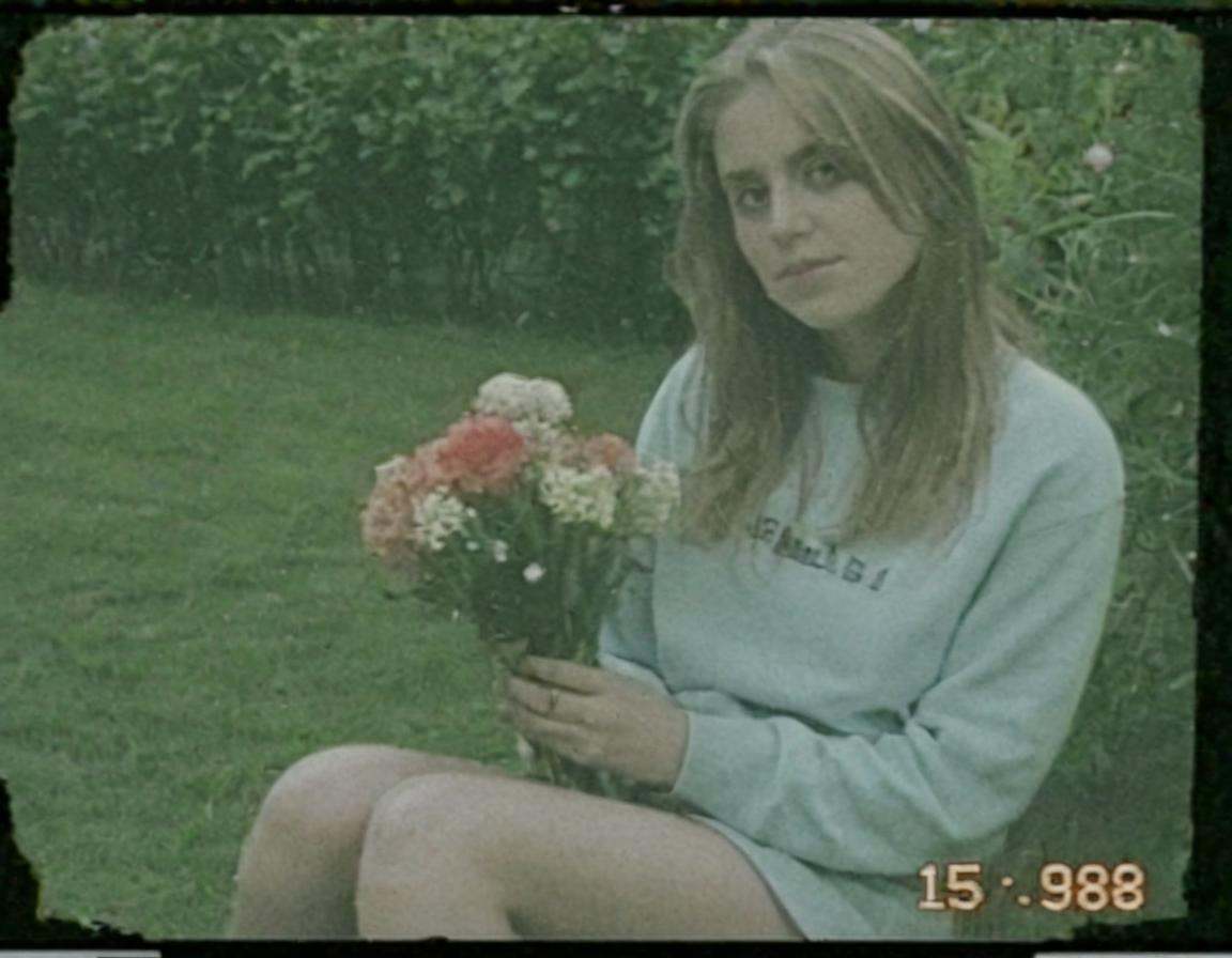 vhscore808,  A woman sitting in a garden,  holding a bouquet of flowers on Tensor.Art