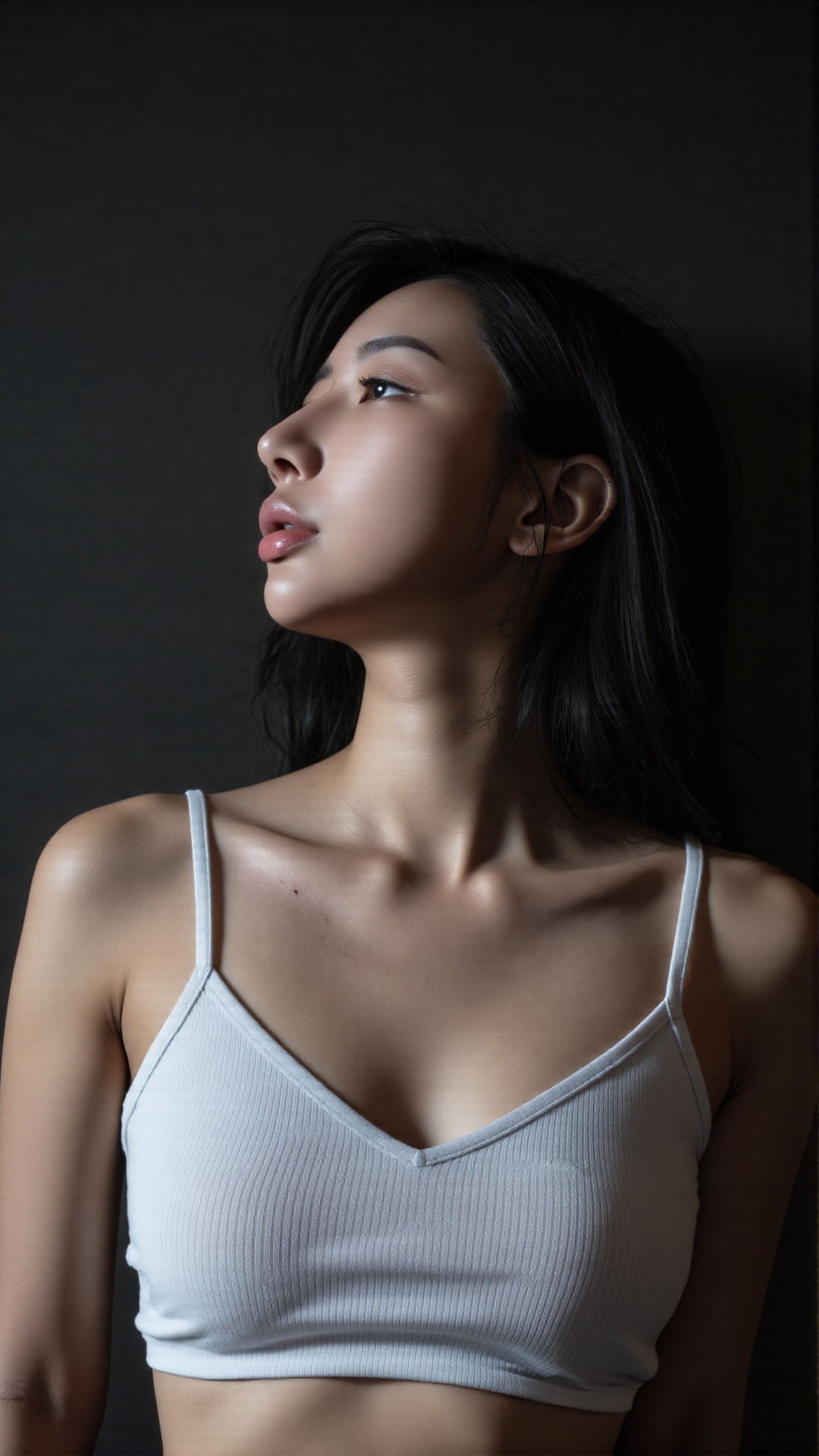 Close up portrait of a young Asian woman. Her head is tilted slightly back and her face is covered by tousled locks,  givi...