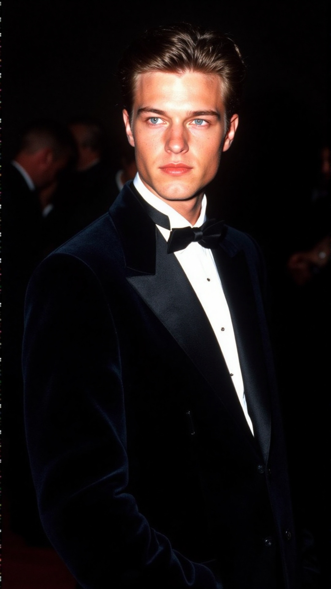 a 2000s paparazzi photo of a 18 years old handsome young man,  he is wearing a black velvet tuxedo by Gucci by Tom Ford. H...