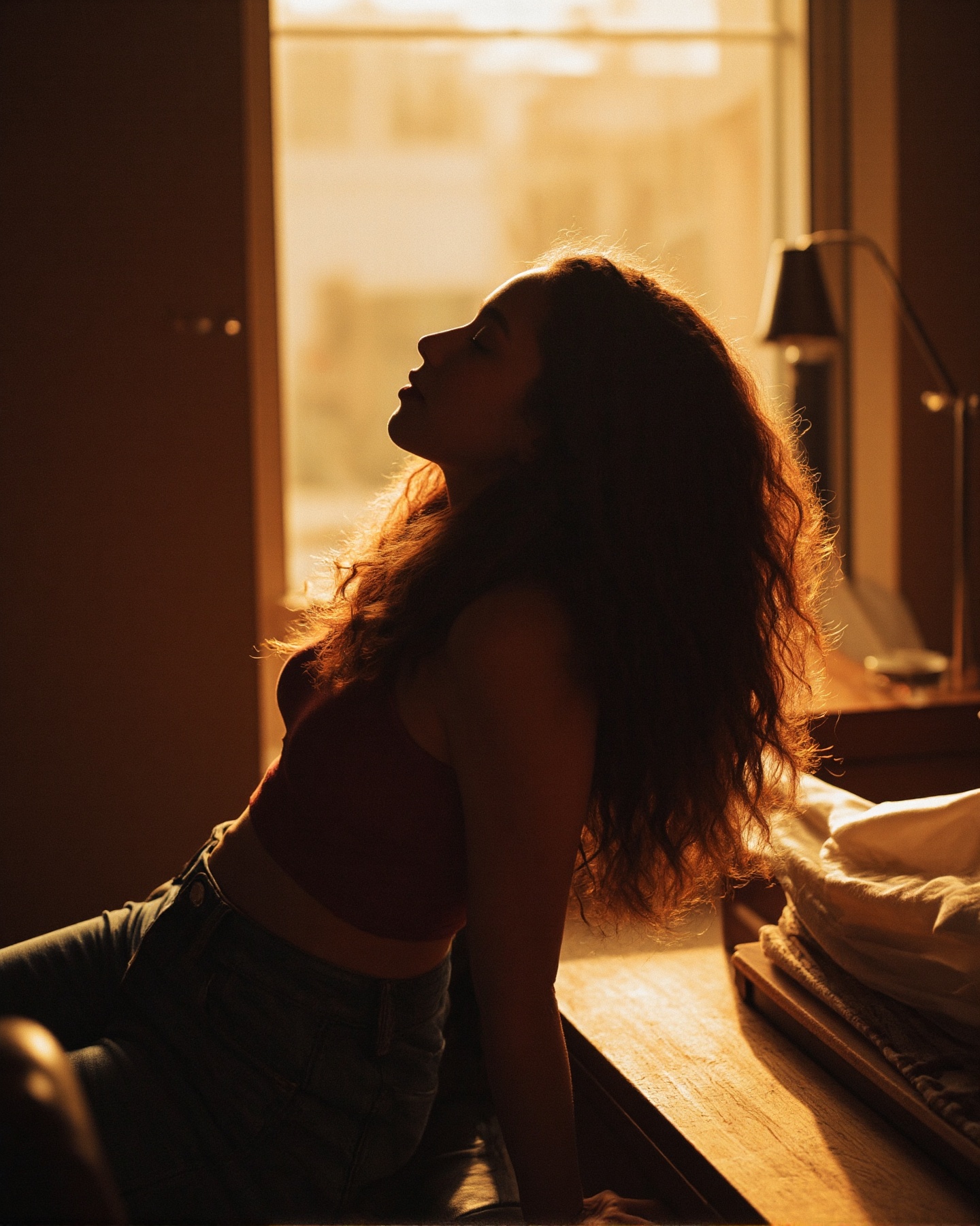 A photograph captures a woman with long,  curly hair in a dimly lit room,  bathed in warm on Tensor.Art