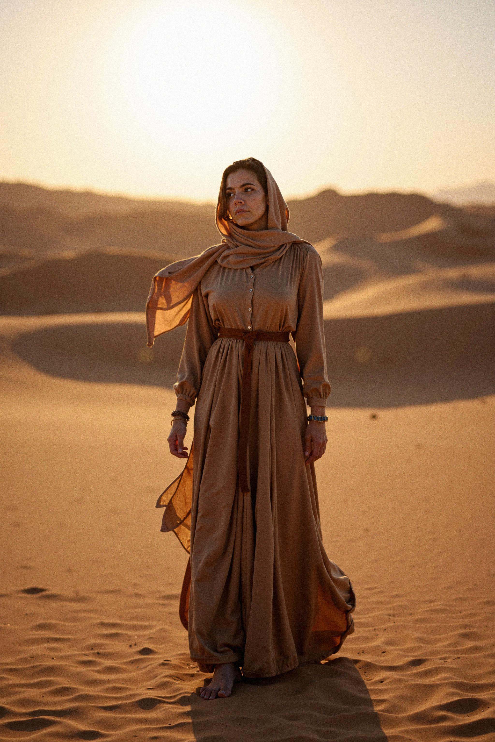 A woman stands in the middle of a sprawling desert at dusk,  captured in a full-body shot that shows her flowing desert ro...