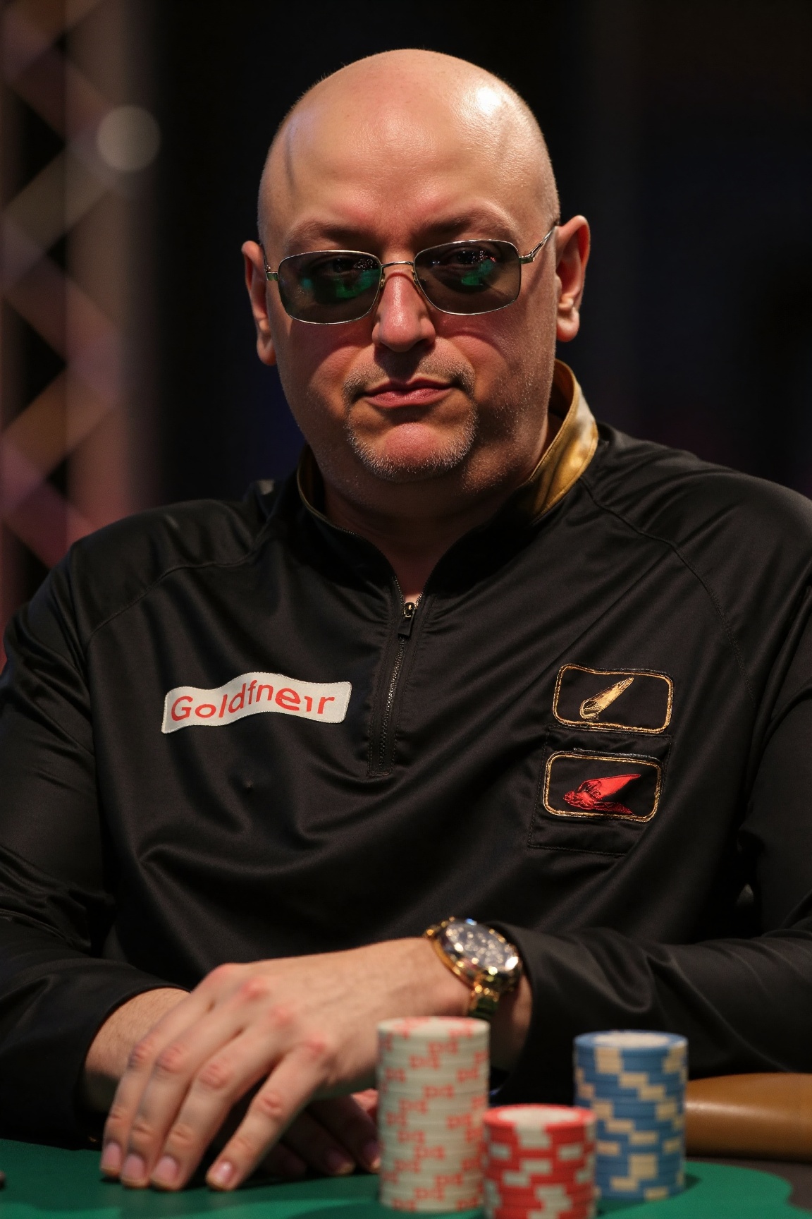 A high-resolution professional portrait photograph of an AxG man,  sitting at a poker table. he is wearing a shiny black s...