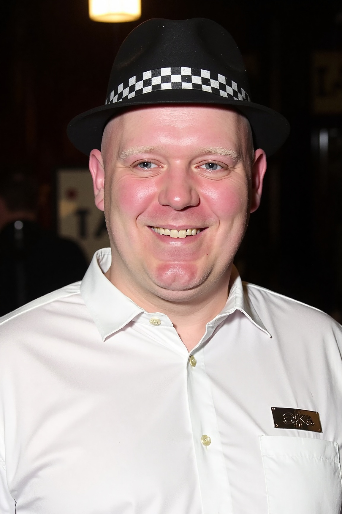 A high resolution professional portrait photograph of mx1 man,  wearing a black & white checkered trilby,  and a crisp whi...