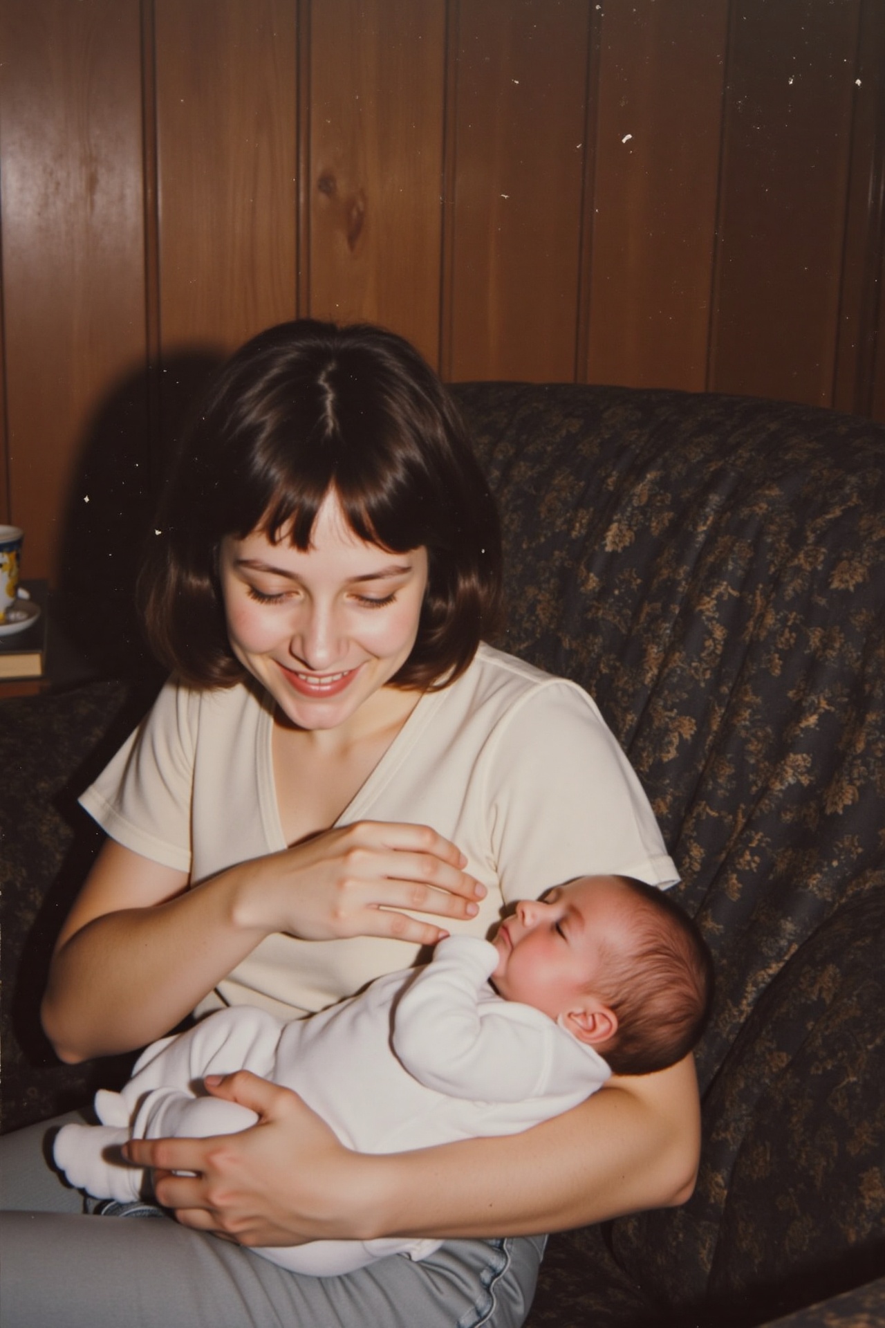 A vintage indoor family photo from the late 80s or early 90s,  showing a young woman with short dark hair and soft bangs s...