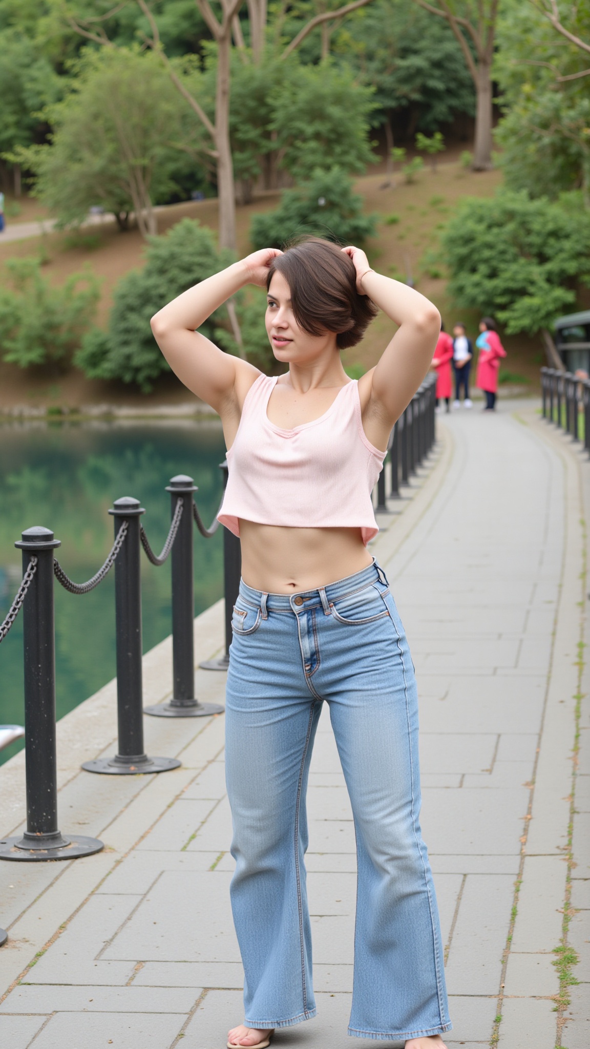 The image shows a person standing outdoors near a body of water. The individual is wearing a light-colored cropped top and...