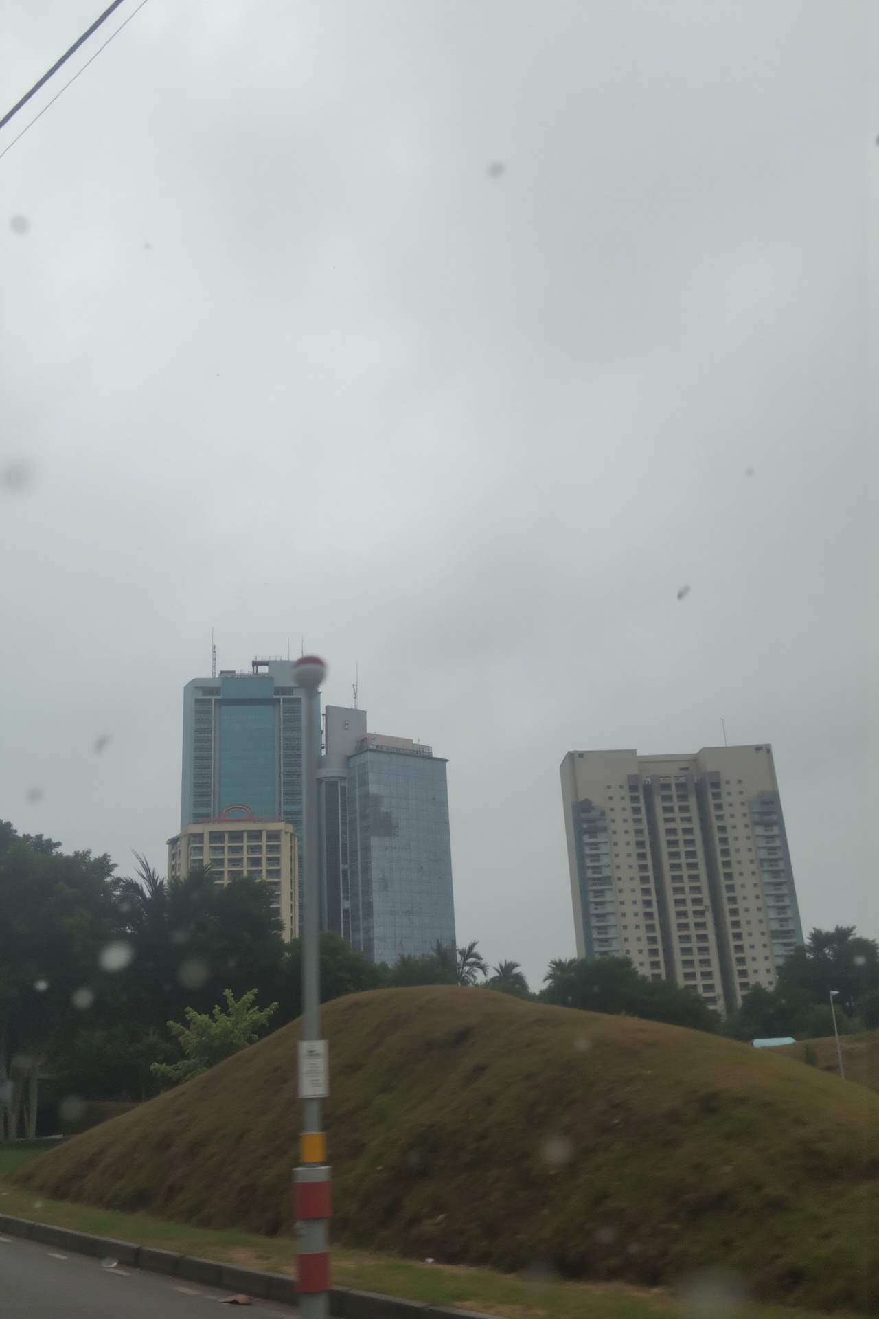 a view of city buildings through a car window on a rainy day,  from inside a vehicle,  phone camera on Tensor.Art
