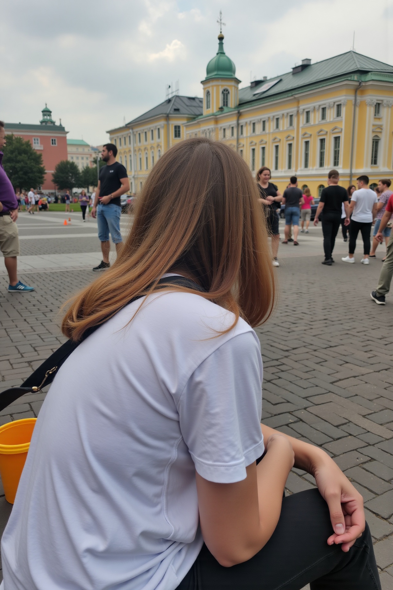 a russian woman in a t-shirt sitting outdoors and looking down at moscow square,  high-angle shot,  phone camera on Tensor...