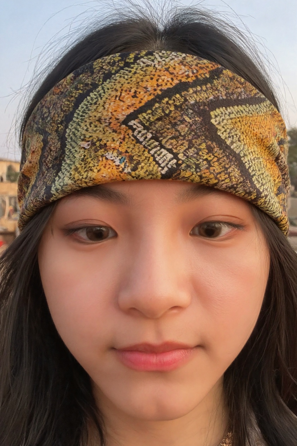 A close-up shot of a young woman's face,  her eyes gazing intensely into the distance. She wears a vibrant serpent-pattern...
