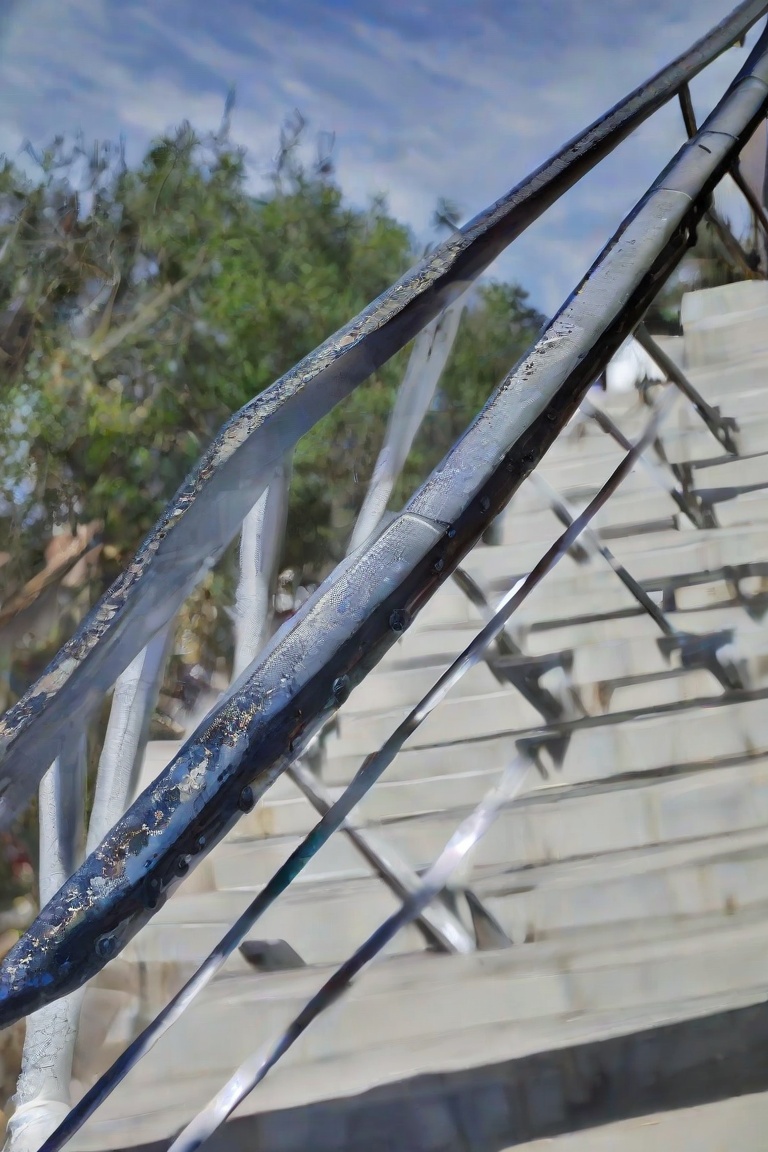 Light and shadow,  The image depicts a close-up view of a metal staircase railing. The railing appears to be made of steel...