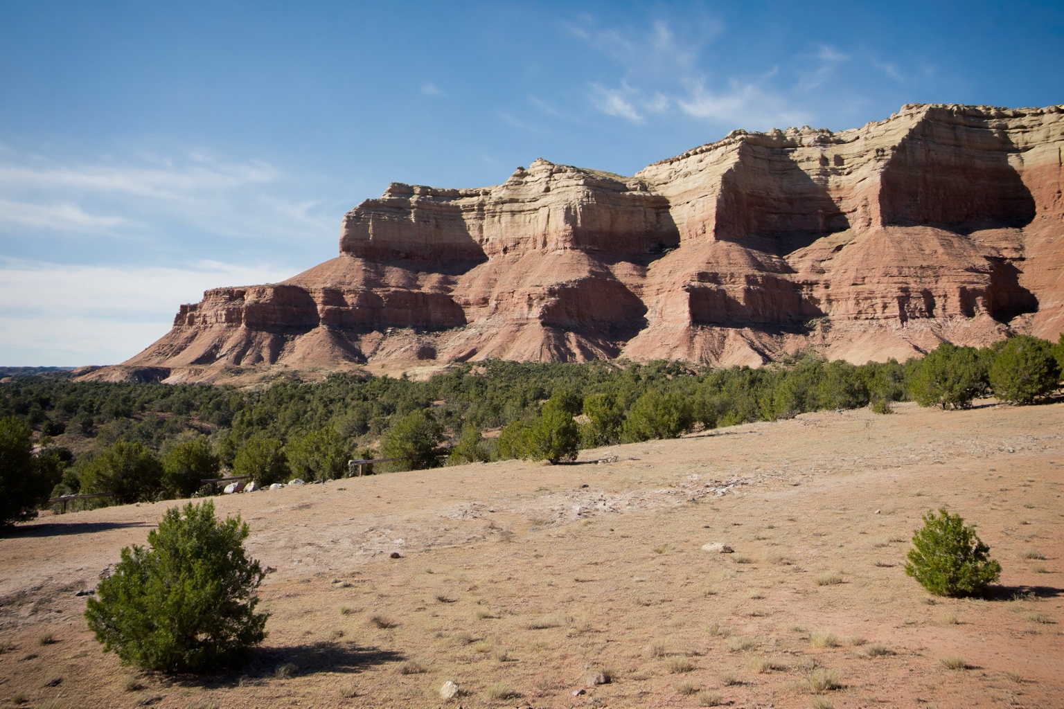 This is a photograph of a western prairie landscape,  captured from an eye-level perspective and composed to highlight the...